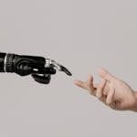 A human hand reaching to touch a bionic prosthetic hand on a white background.